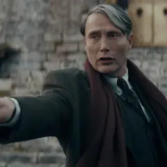 Mads Mikkelsen w roli Grindelwalda, z różdżką w dłoni, w filmie z serii "Fantastyczne zwierzęta".