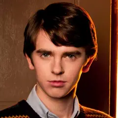 Freddie Highmore w swetrze i koszuli, zamyślony. Jego filmy, seriale i programy często poruszają złożone tematy.
