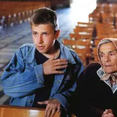 Młody chłopak i starsza kobieta siedzą w kościele. To ja złodziej obsada filmu.