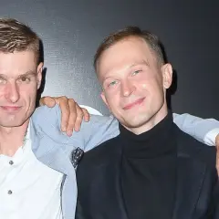 Aktorzy z filmu o Tomaszu Komendzie pozują razem, jeden z nich ma rękę na ramieniu drugiego.