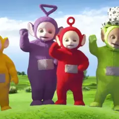 Tinky Winky, Dipsy, Laa-Laa i Po – teletubisie imiona znane dzieciom. Wesołe postacie machają do widzów na zielonej łące.