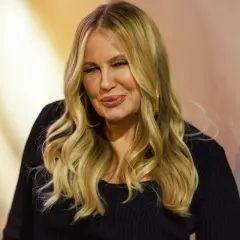Jennifer Coolidge, znana jako mama Stiflera, z charakterystycznym uśmiechem i blond włosami.