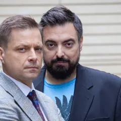 Dwóch mężczyzn, twórcy filmu braci Sekielskich, patrzy w obiektyw. Jeden w garniturze, drugi w marynarce i t-shircie.