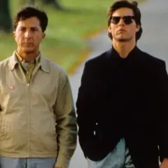 Dustin Hoffman i Tom Cruise idą razem. Hoffman, jako "rain man", ma na sobie beżową kurtkę.