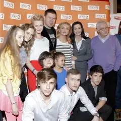 Rodzinka.pl obsada: młodzi i starsi aktorzy pozują do zdjęcia. W tle logo TVP 2 i rodzinka.pl.