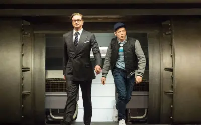 Colin Firth i Taron Egerton, czyli gwiazdy Kingsman: Tajne Służby, wychodzą zza masywnych drzwi.