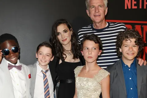 Aktorzy Stranger Things: Winona Ryder, Millie Bobby Brown, Gaten Matarazzo, Noah Schnapp, Caleb McLaughlin i Matthew Modine pozują do zdjęcia.