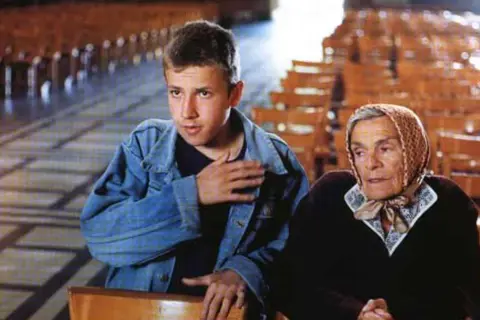 Młody chłopak i starsza kobieta siedzą w kościele. To ja złodziej obsada filmu.