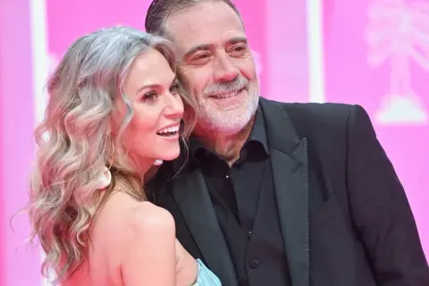 Jeffrey Dean Morgan, znany z filmów, seriali i programów, uśmiecha się do swojej żony na różowym tle.