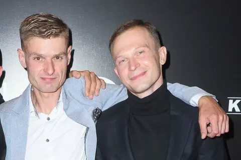 Aktorzy z filmu o Tomaszu Komendzie pozują razem, jeden z nich ma rękę na ramieniu drugiego.