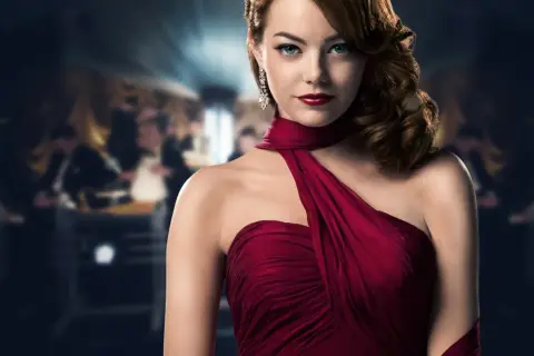 Emma Stone w czerwonej sukni, w tle rozmyta sala balowa, jak z filmu "Strefa gangsterów obsada".