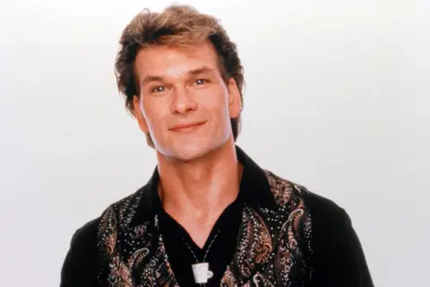 Patrick Swayze, gwiazda kultowych **patrick swayze filmy**, w charakterystycznej koszuli z wzorem.