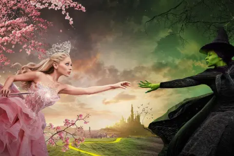 Królowa w różowej sukni i zielona wiedźma z "Wicked 2" wyciągają do siebie ręce na tle baśniowego krajobrazu.