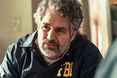 Mark Ruffalo w kurtce FBI, przypominający postać z jego filmów, seriali i programów.
