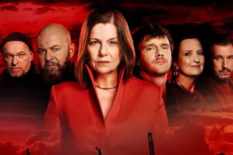 Krew z krwi obsada: poważne twarze, czerwone tło. Grupa ludzi, w tym kobieta w czerwonej marynarce, przygotowuje się na coś groźnego.