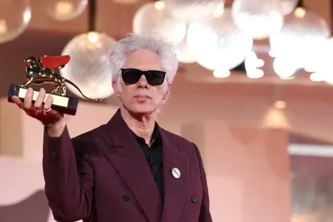 Jim Jarmusch z Złotym Lwem, główna nagroda festiwalu filmowego w Wenecji, w dłoni.