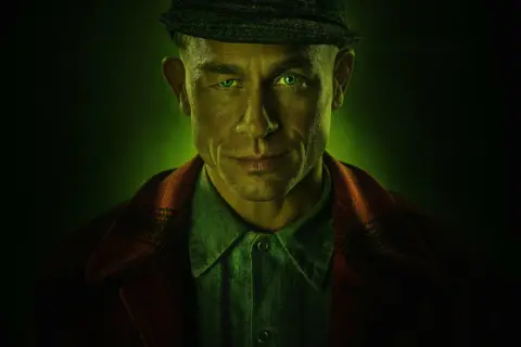 Mężczyzna z zielonymi oczami i czapką na głowie, zapowiedź mrocznych netflix seriali kryminalnych.