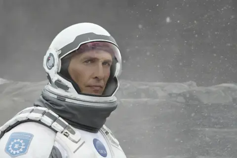Astronaut Cooper z filmu Interstellar 2 w skafandrze kosmicznym, na tle zamarzniętego krajobrazu.