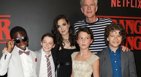 Aktorzy Stranger Things: Winona Ryder, Millie Bobby Brown, Gaten Matarazzo, Noah Schnapp, Caleb McLaughlin i Matthew Modine pozują do zdjęcia.