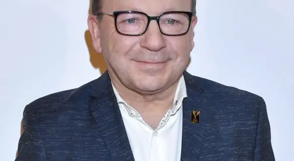 Zbigniew Zamachowski w garniturze i okularach, znany z wielu polskich filmów.