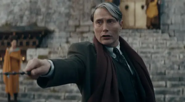 Mads Mikkelsen w roli Grindelwalda, z różdżką w dłoni, w filmie z serii "Fantastyczne zwierzęta".