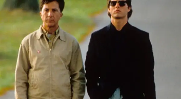 Dustin Hoffman i Tom Cruise idą razem. Hoffman, jako "rain man", ma na sobie beżową kurtkę.