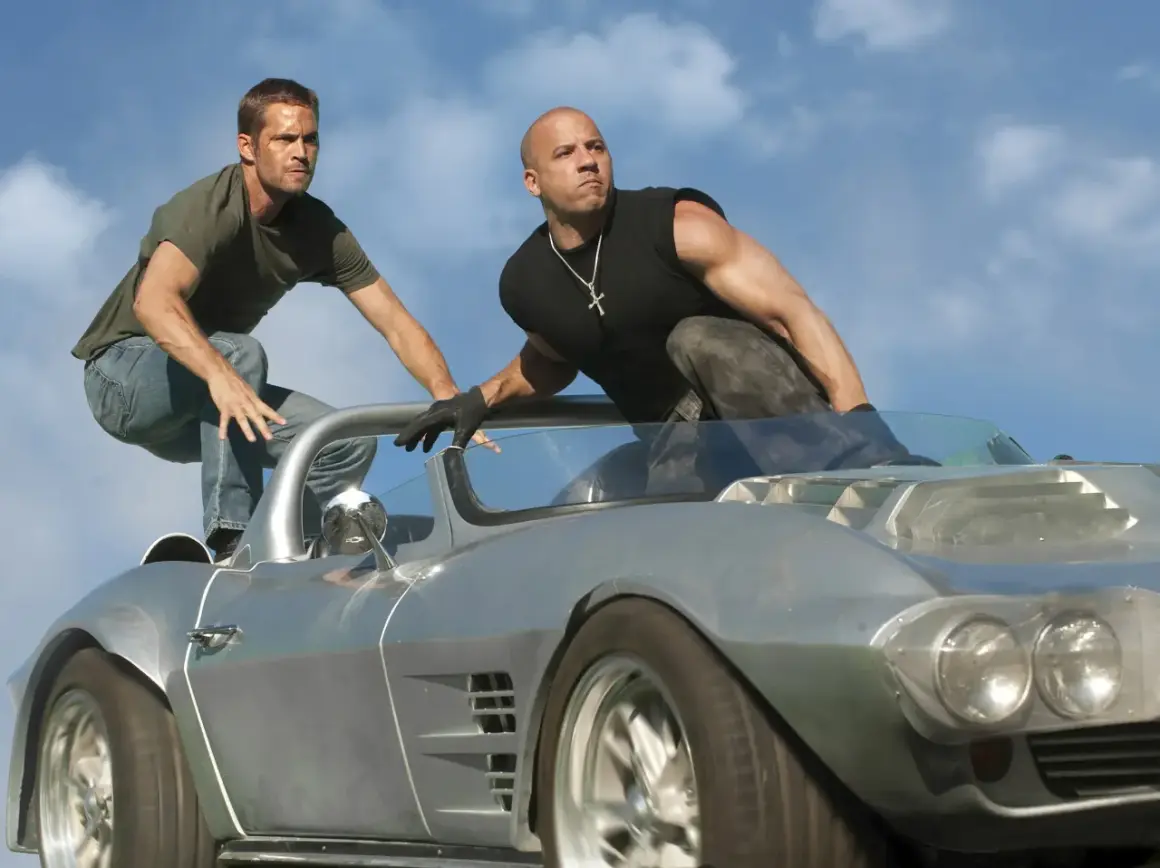Szybcy i wściekli 5 obsada: Vin Diesel i Paul Walker w akcji na dachu samochodu.