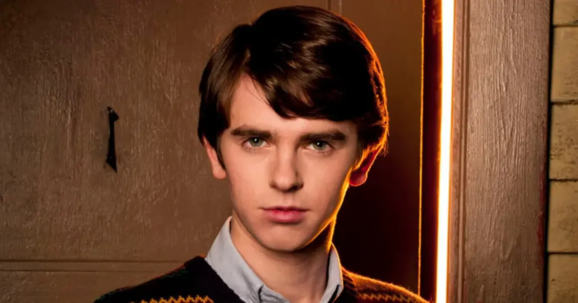 Freddie Highmore w swetrze i koszuli, zamyślony. Jego filmy, seriale i programy często poruszają złożone tematy.