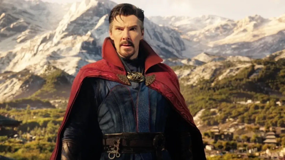 Doktor Strange w multiwersum obłędu obsada. Benedict Cumberbatch jako Strange w czerwonym płaszczu i niebieskim stroju na tle gór.