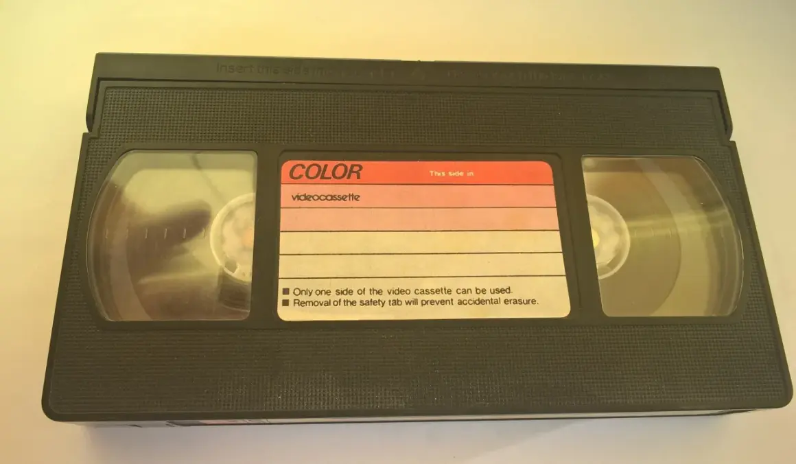 Czarna kaseta wideo z etykietą "COLOR videocassette". Widać dwie rolki taśmy.
