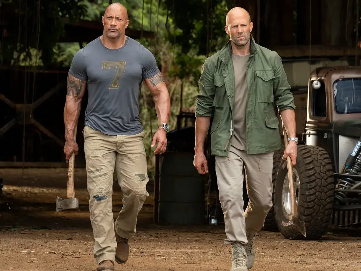 Hobbs i Shaw obsada: Dwayne Johnson i Jason Statham idą z siekierami, gotowi na akcję w dżungli.