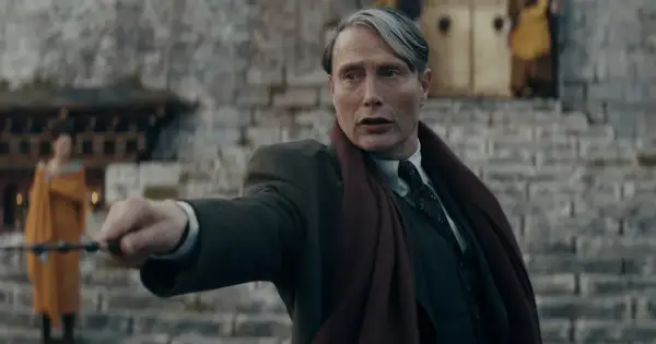 Mads Mikkelsen w roli Grindelwalda, z różdżką w dłoni, w filmie z serii "Fantastyczne zwierzęta".