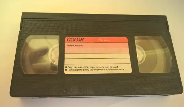 Czarna kaseta wideo z etykietą "COLOR videocassette". Widać dwie rolki taśmy.