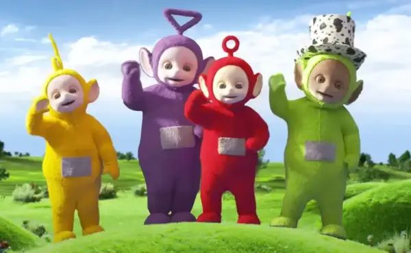 Tinky Winky, Dipsy, Laa-Laa i Po – teletubisie imiona znane dzieciom. Wesołe postacie machają do widzów na zielonej łące.