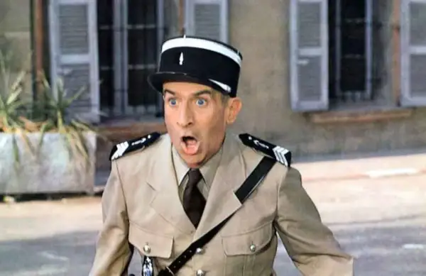 Louis de Funès w filmach, w mundurze żandarma, z miną pełną zdziwienia i rozbawienia.