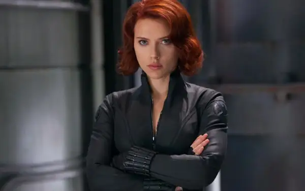 Czarna Wdowa Marvel, w czarnym kombinezonie, z rudymi włosami, pewnie patrzy przed siebie.