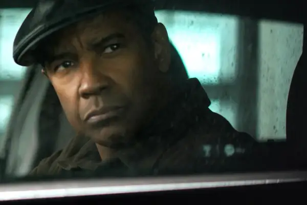 Denzel Washington w czapce siedzi w samochodzie, jego spojrzenie jest intensywne, jakby działał bez litości 4.