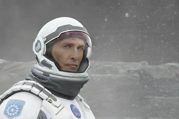 Astronaut Cooper z filmu Interstellar 2 w skafandrze kosmicznym, na tle zamarzniętego krajobrazu.